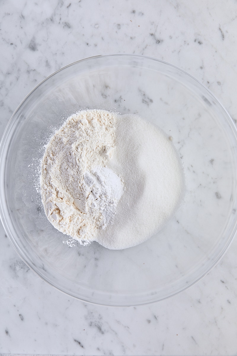 Flour, granulated sugar, baking powder, baking soda, and salt in glass bowl