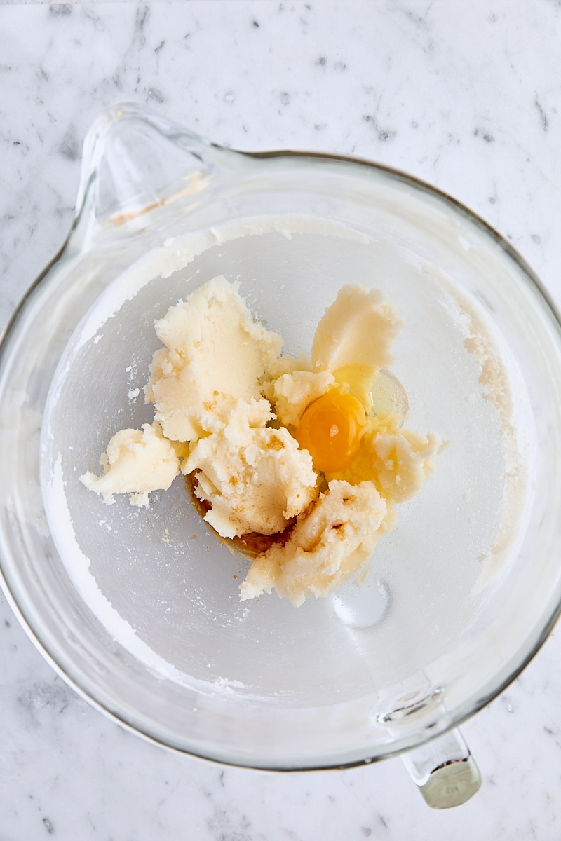 Egg and vanilla extract added to batter in glass mixing bowl