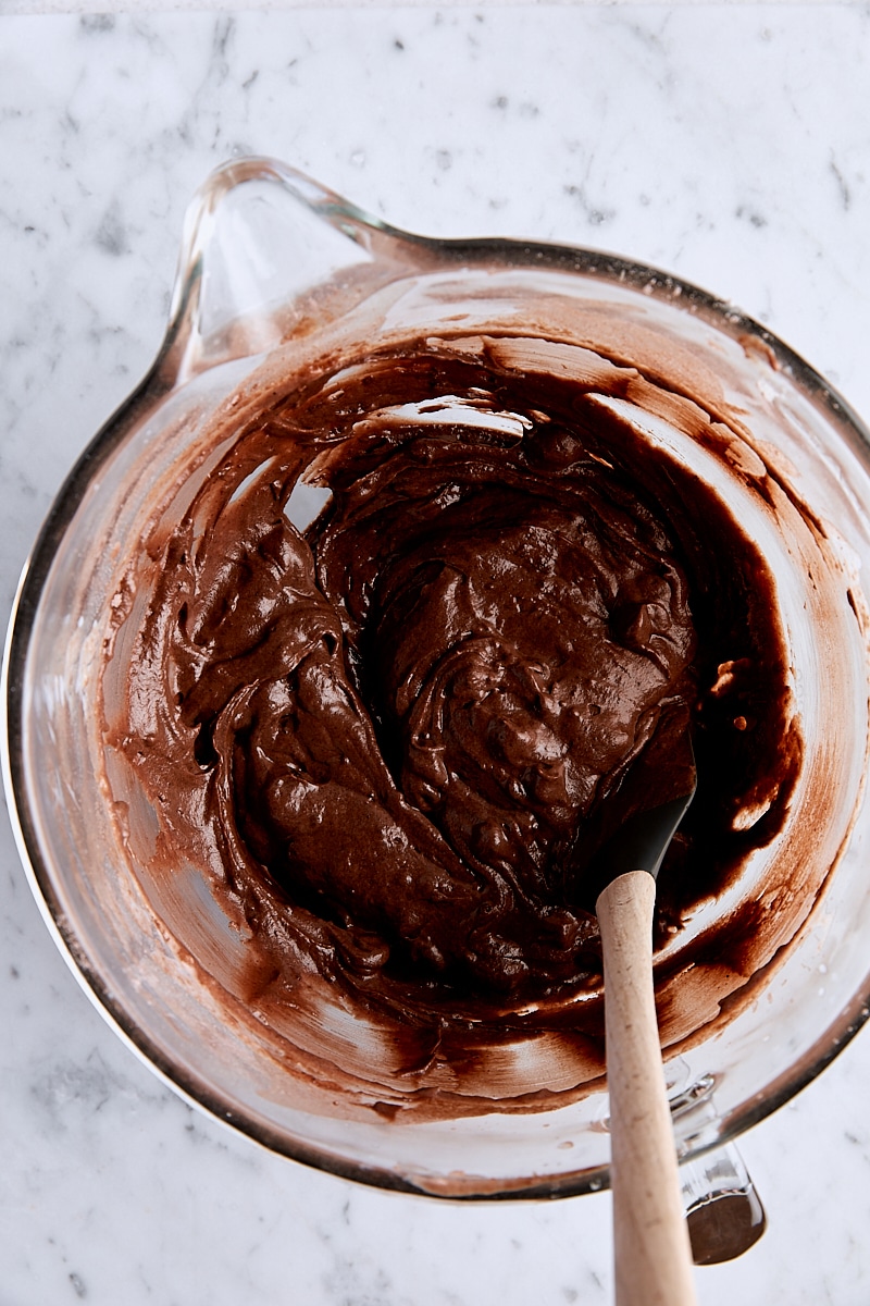 Triple chocolate loaf cake batter in glass mixing bowl with spatula