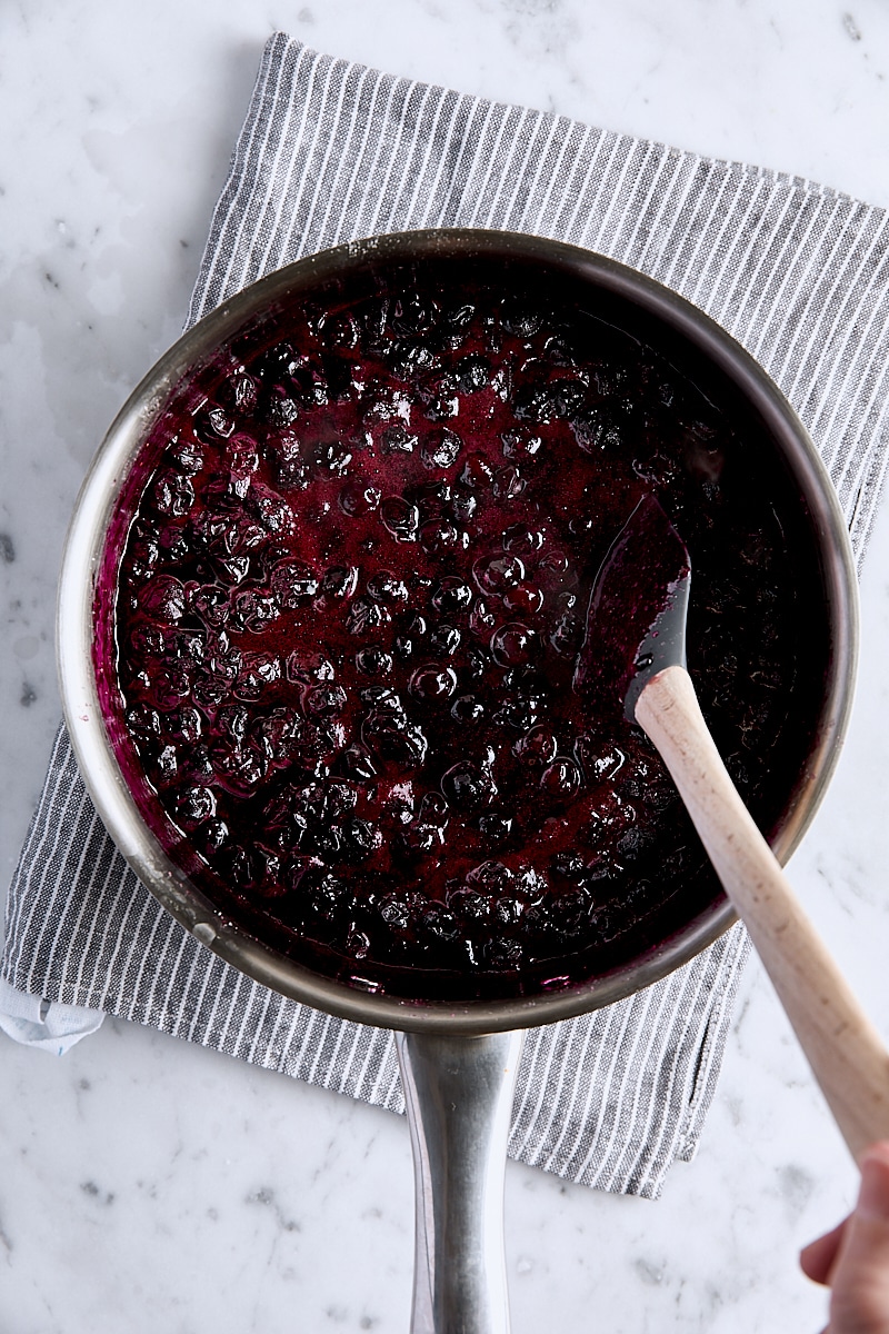 Blueberries cooked until reduced and softened in saucepan