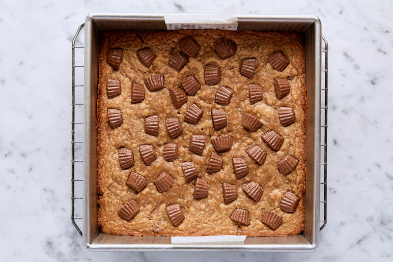 Baked peanut butter blondies in parchment-lined square pan