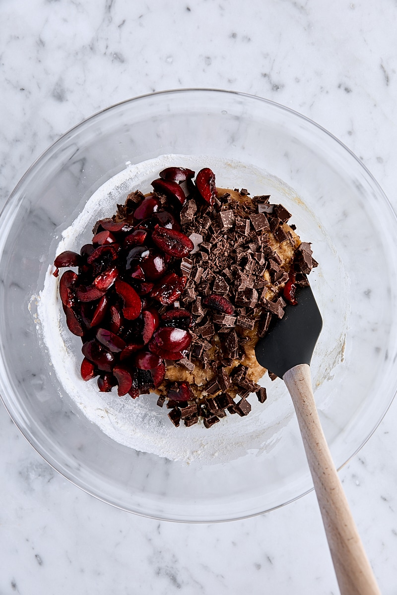 Cherries and semisweet chocolate added to blondie batter in glass bowl