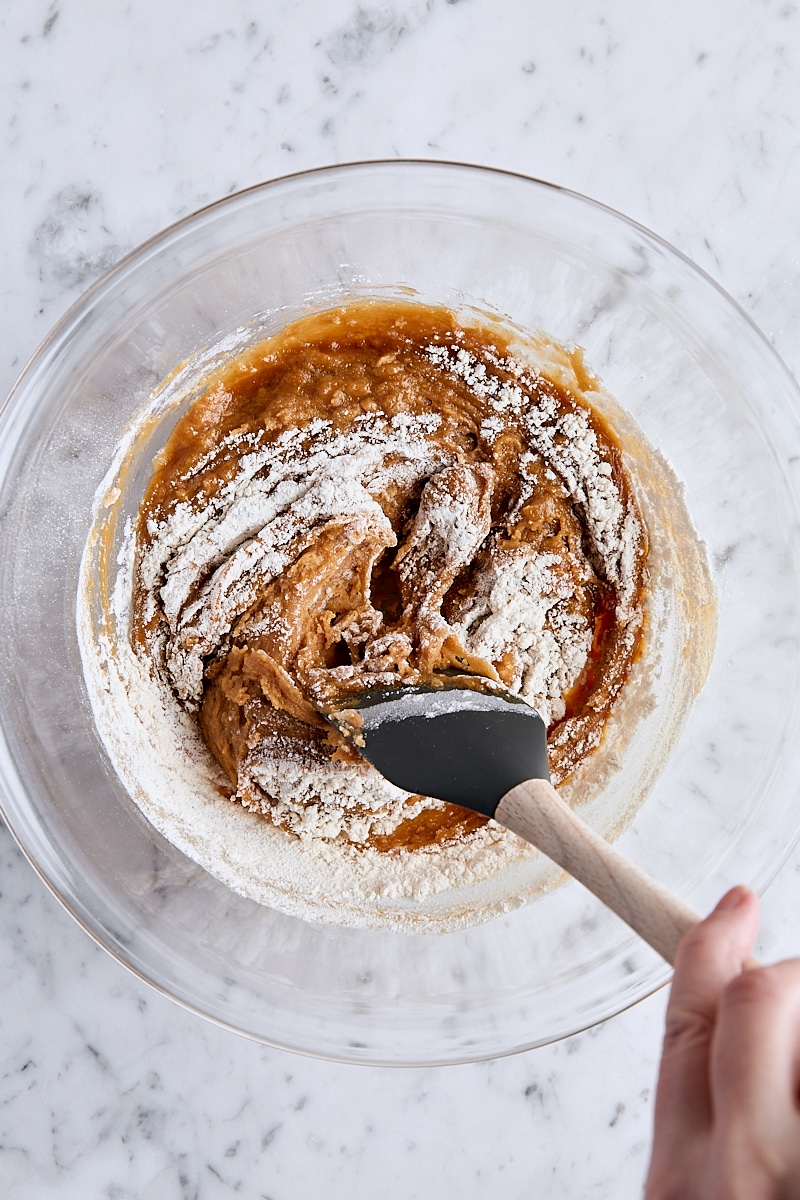 Folding flour into peanut butter blondie batter with spatula