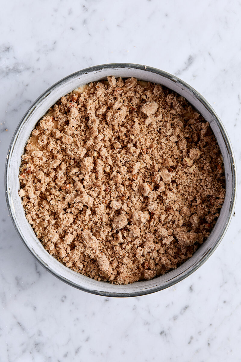 Coffee cake batter sprinkled with half of the streusel topping