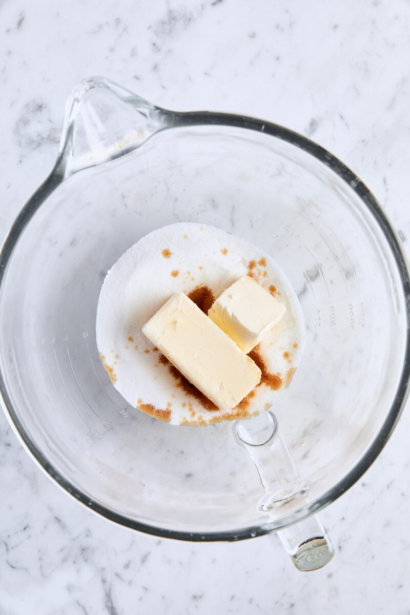 Room temperature butter, granulated sugar, and vanilla extract in glass mixing bowl