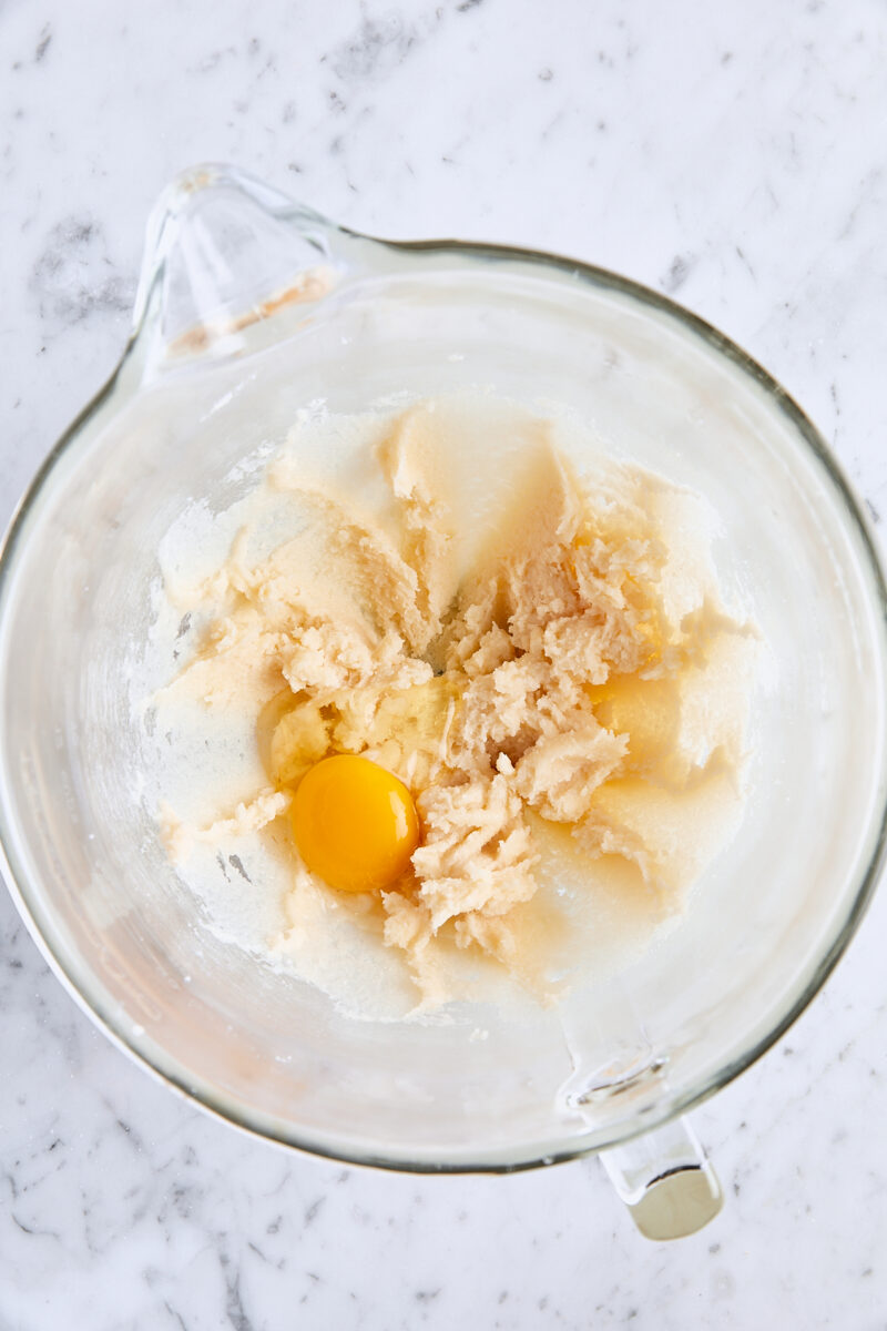Egg added to batter in glass mixing bowl