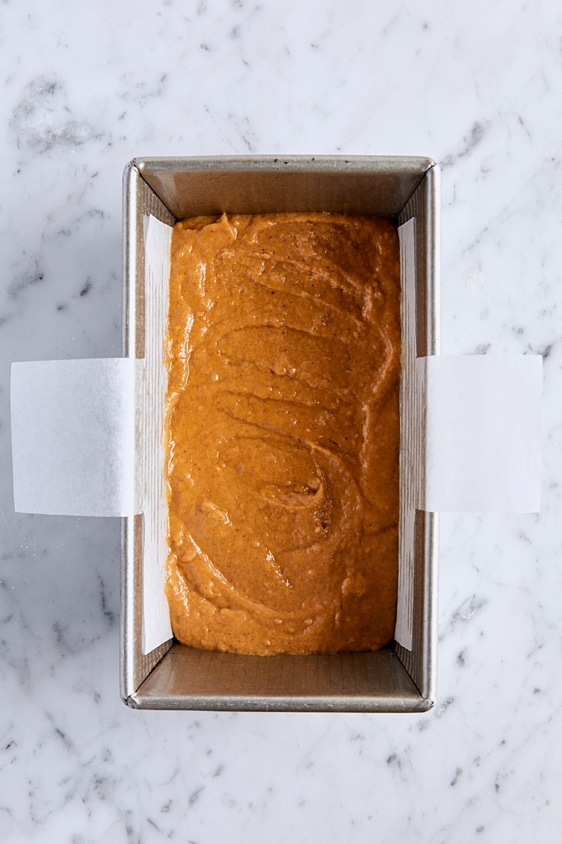 Half of the pumpkin bread batter in parchment-lined loaf pan
