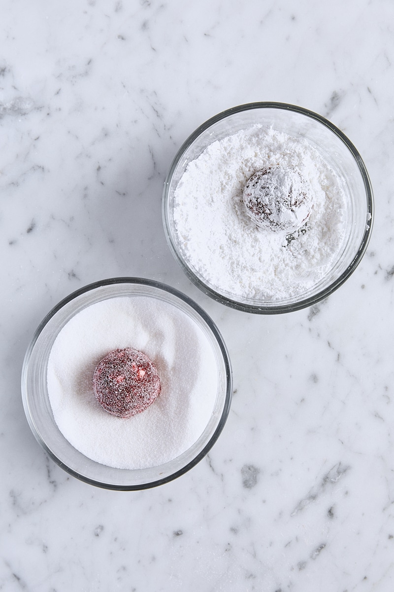 Red velvet cookie dough rolled in granulated sugar and coated in powdered sugar