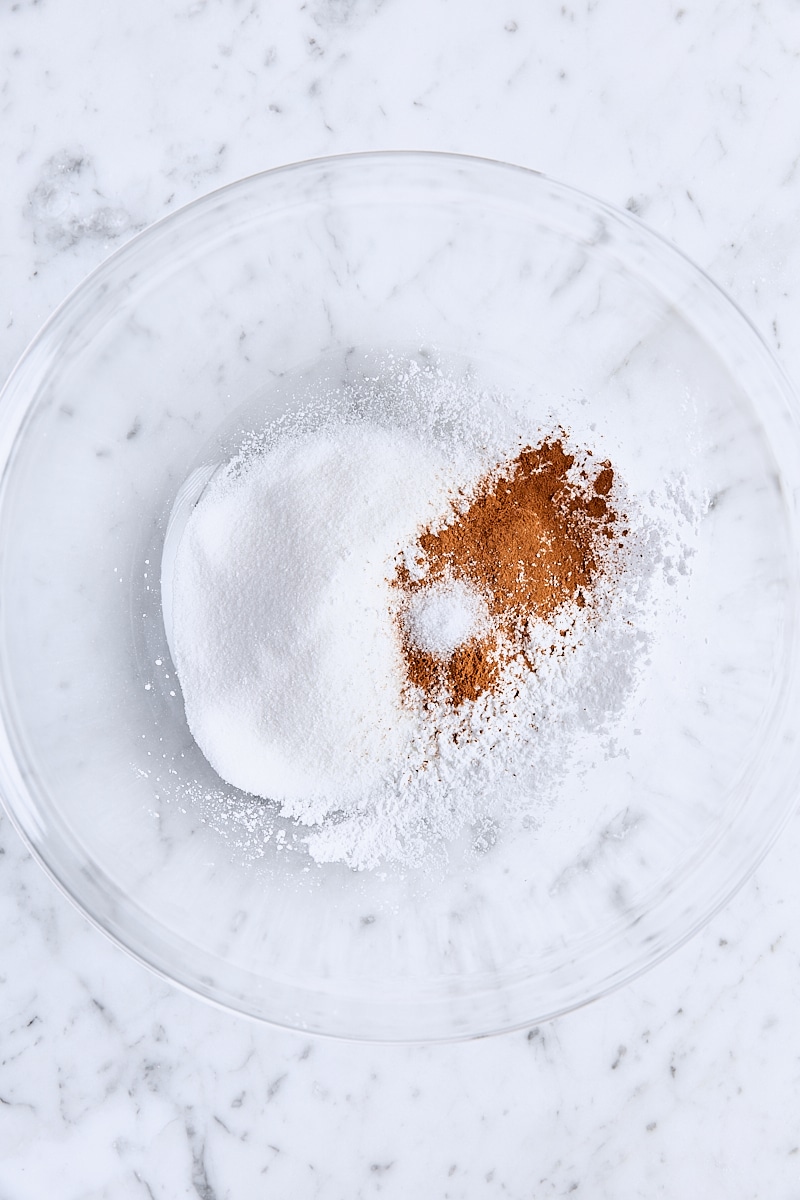 Granulated sugar, cornstarch, ground cinnamon, and salt in large glass bowl