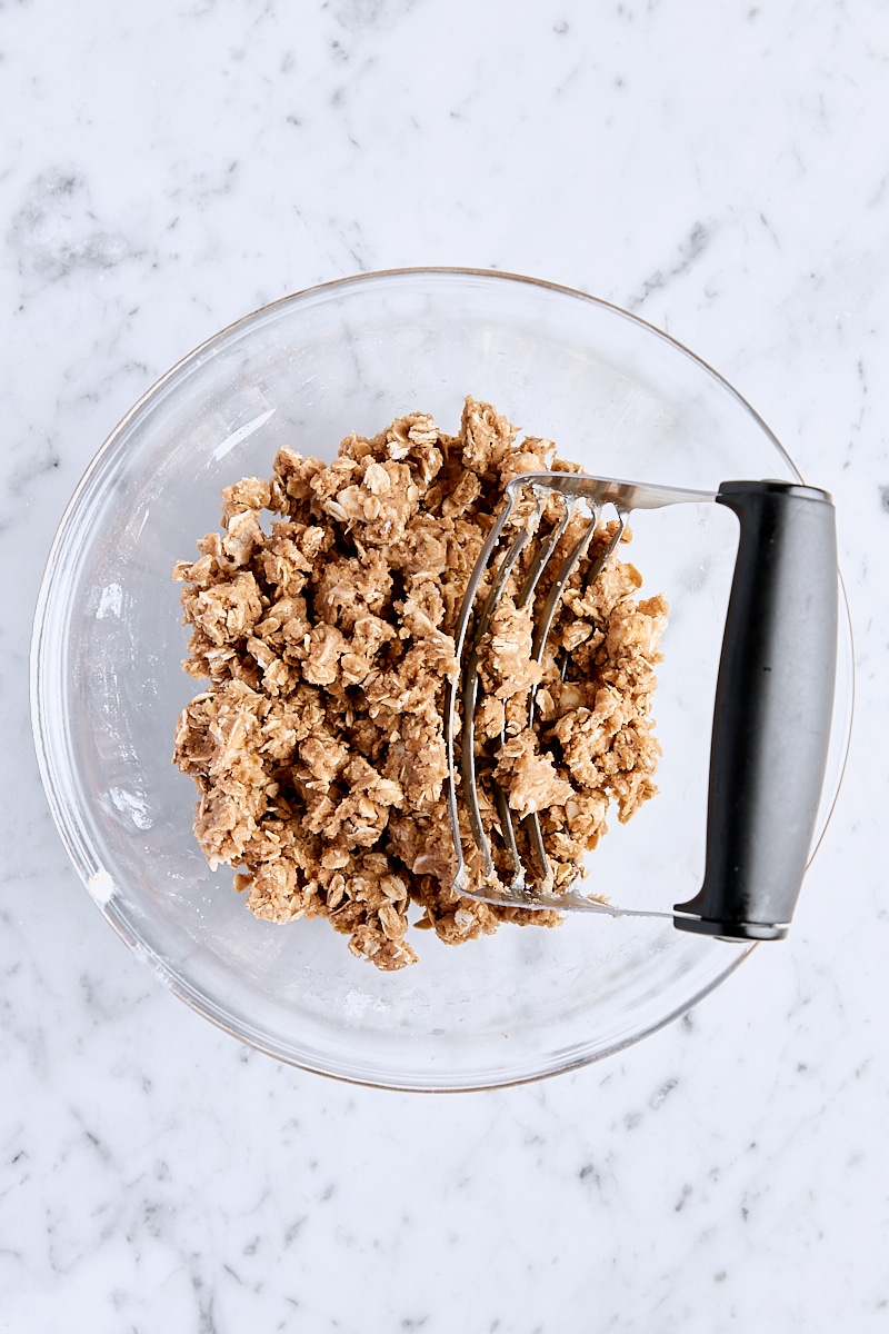 Cubed butter cut into oatmeal mixture with a pastry cutter