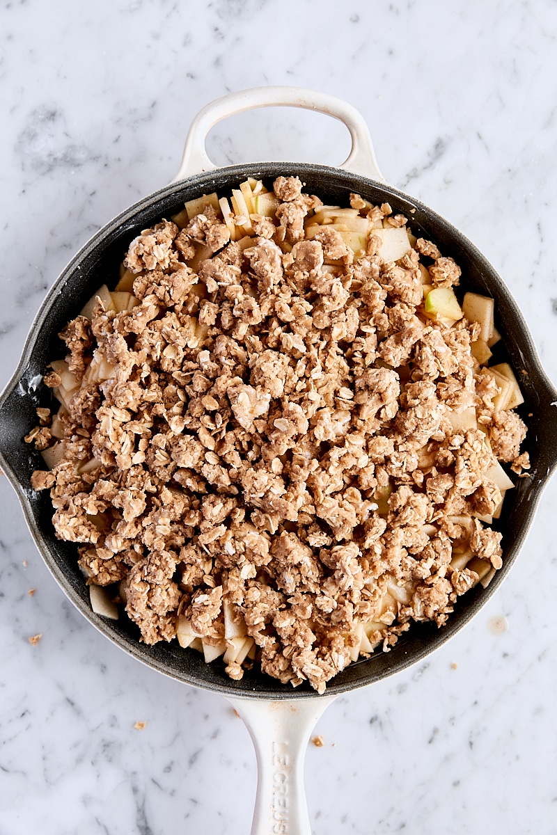 Assembled un-baked apple crisp in cast-iron skillet