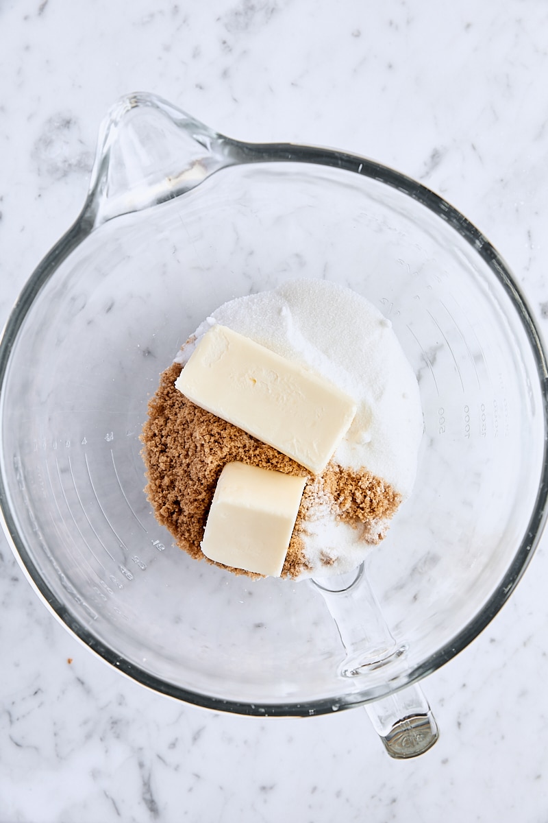 Unsalted butter, dark brown sugar, and granulated sugar in glass mixing bowl