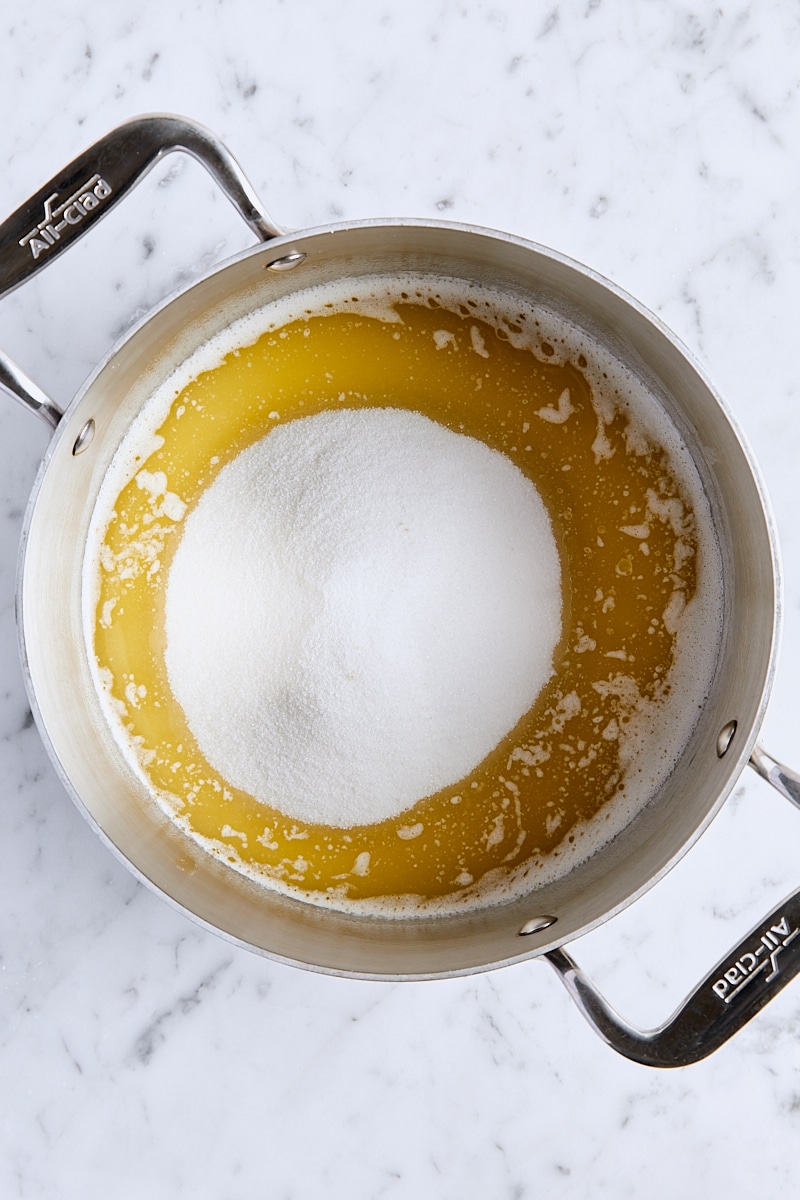 Granulated sugar added to saucepan with melted butter