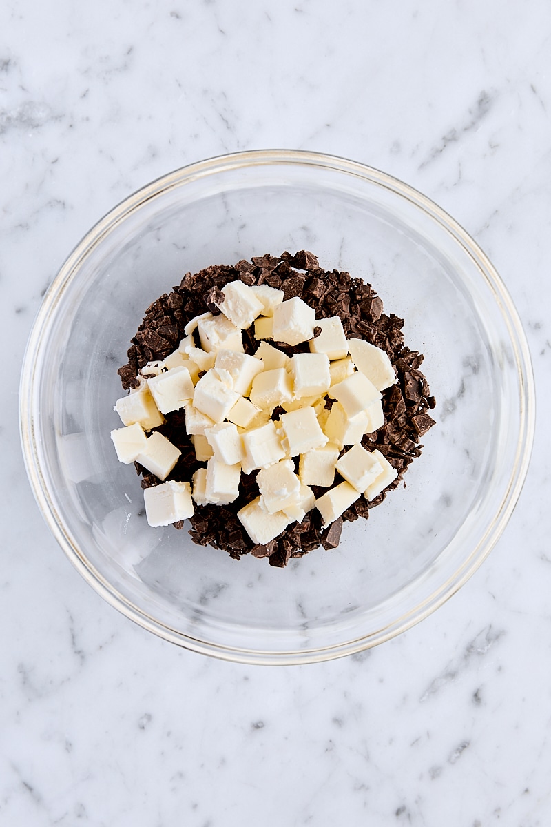 Cubed butter and chopped semisweet chocolate in small glass bowl