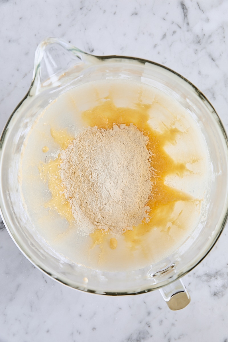 Dry ingredients added to batter in glass mixer bowl