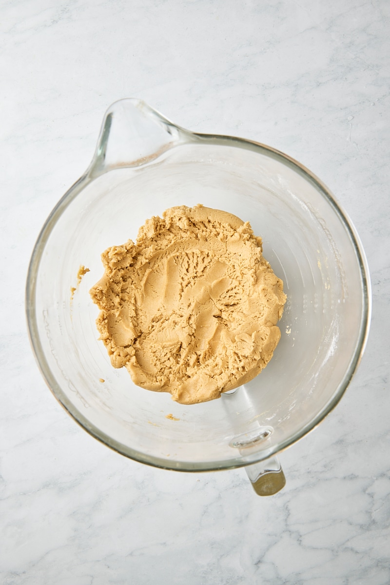 Peanut butter cookie dough in glass mixer bowl